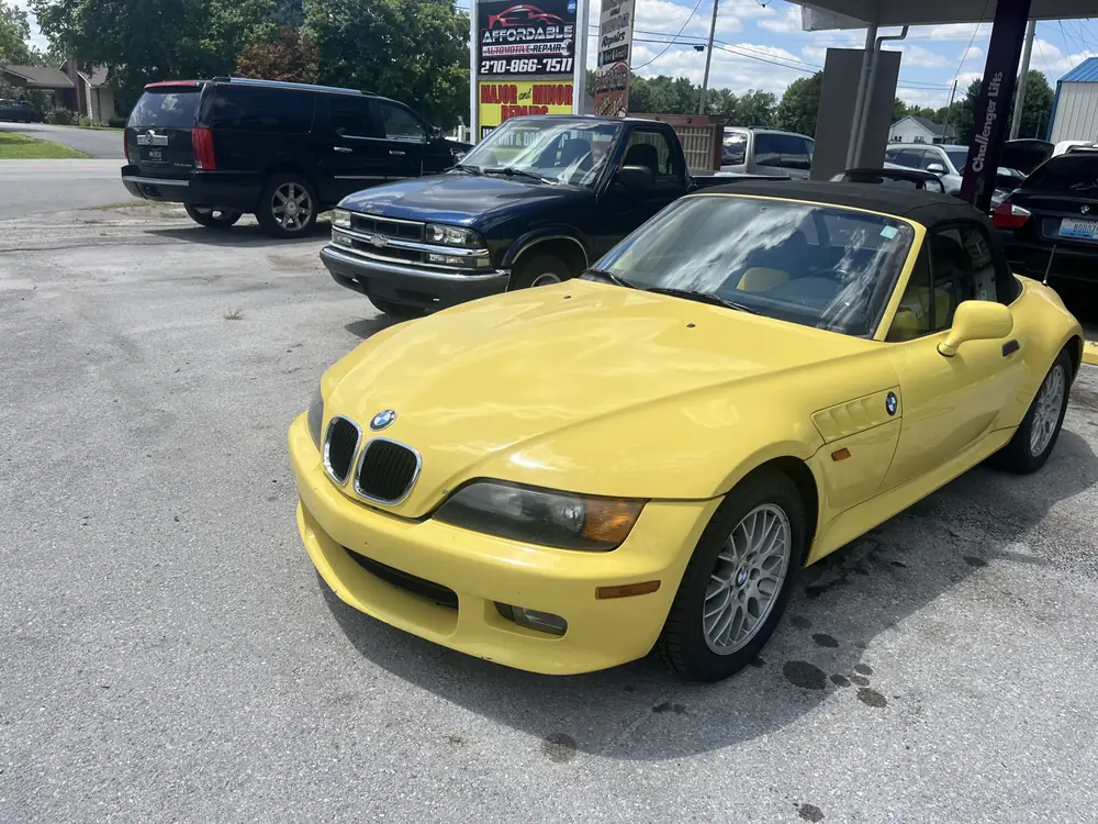 Yellow BMW Z3 roadster parked at the shop