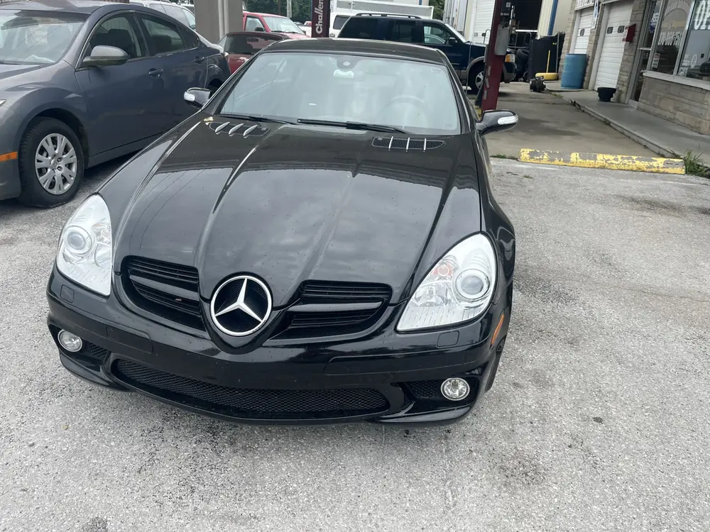 Black Mercedes-Benz SLK roadster parked at the shop