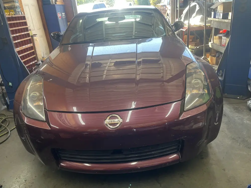 Front of a burgundy Nissan 350Z in the service bay