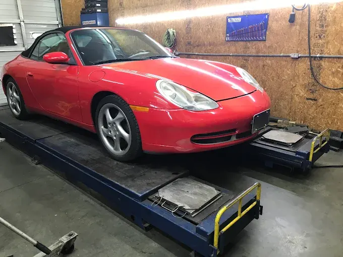 Red Porsche 911 Cabriolet on the lift in the service bay